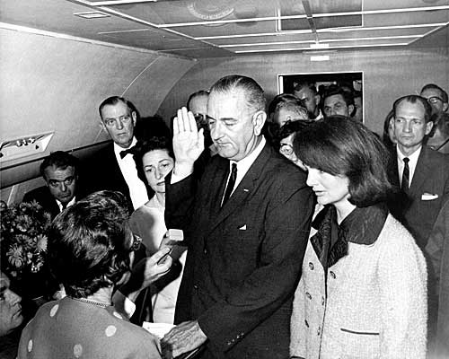 With Jacqueline Kennedy beside him, Vice President Lyndon B. Johnson is sworn in as president by U.S. District Judge Sarah T. Hughes, left. 