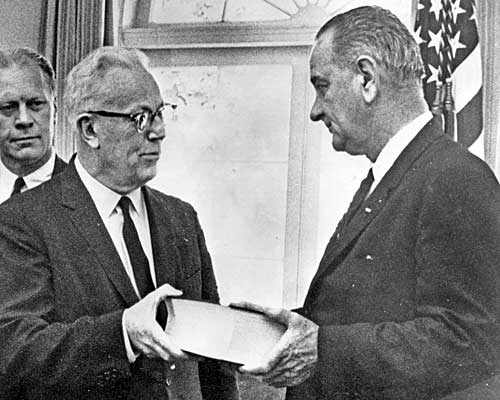 Warren gives President Johnson a report on the assassination of President John F. Kennedy. Looking on is Warren Commission member and Michigan Rep. Gerald Ford. Ford will become president after Richard Nixon, the man Kennedy defeated, resigns the presidency 10 years later.
