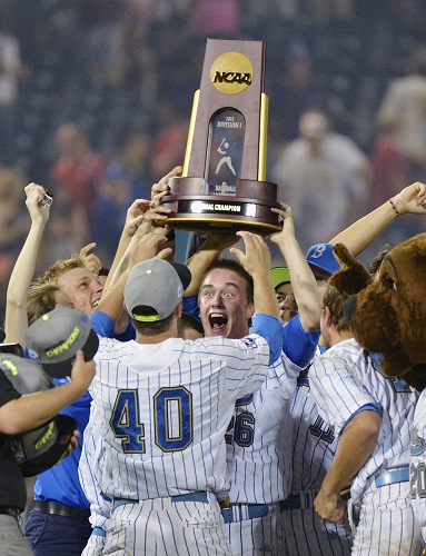 UCLA closer David Berg stands in front of teammate Ryan Deeter while holding the NCAA championship trophy following their 8-0 victory over Mississippi State in Game 2 of the College World Series on Tuesday. 