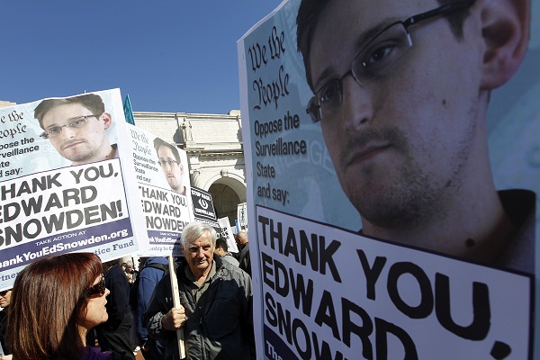 Demonstrators protest U.S. surveillance practices with signs applauding NSA leaker Edward Snowden.