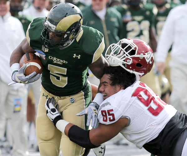 Washington State nose tackle Ioane Gauta loses his helmet as he hits Colorado State running back Kapri Bibbs. Bibbs rushed for three touchdowns in the Rams' 48-45 win over the Cougars.