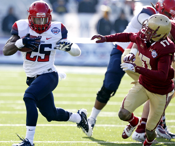 Arizona running back Ka'Deem Carey, who rushed for 169 yards and two touchdowns, evades Boston College defensive back Bryce Jones in the second half of the AdvoCare V100 Bowl.