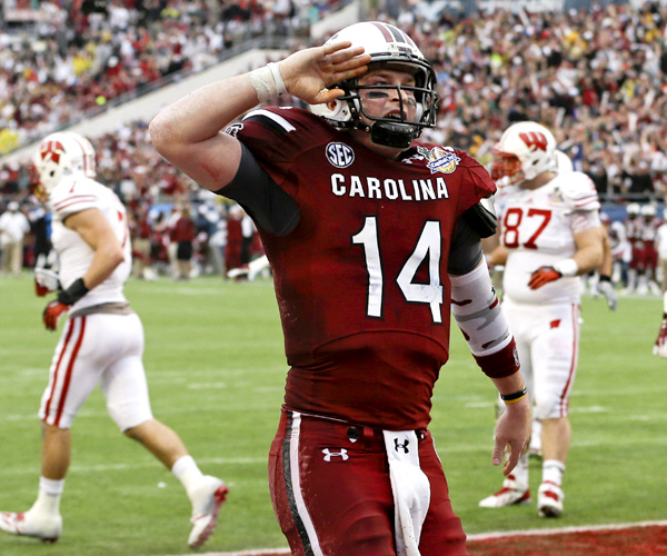 South Carolina quarterback Connor Shaw salutes fans after catching a touchdown on a pass from receiver Bruce Ellington in the first half of the Capital One Bowl. Shaw, the game's MVP, also passed for three touchdowns and ran for another.