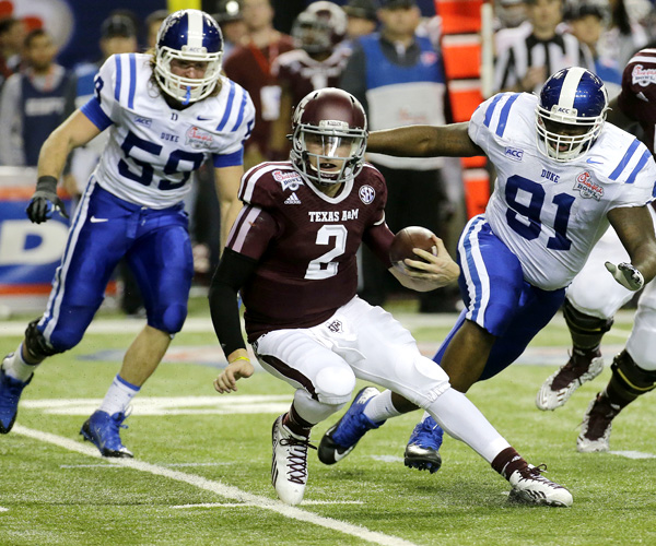 Texas A&M quarterback Johnny Manziel, who passed for four touchdowns and ran for one, tries to escape the pressure of Duke linebacker Kelby Brown (59) and nose tackle Jamal Bruce (91) in the first half of the Chick-fil-A Bowl.