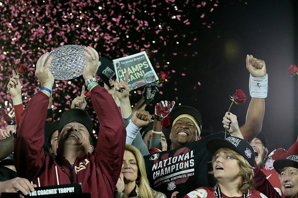 Florida State Coach Jimbo Fisher hoists The Coaches' Trophy as he celebrates with his family and quarterback Jameis Winston following the Seminoles' 34-31 win over Auburn for the BCS title at the Rose Bowl.