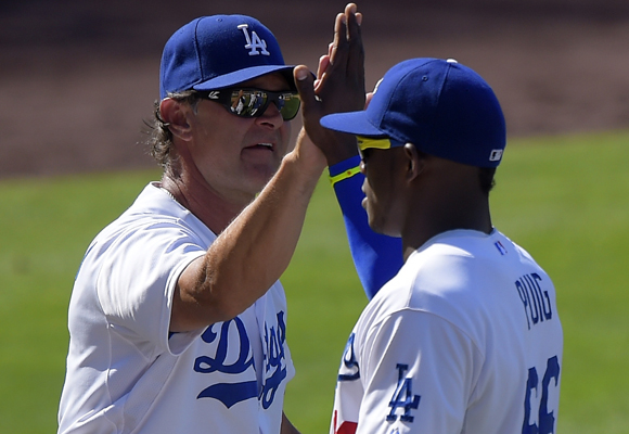 Dodgers Manager Don Mattingly, left, celebrates with right fielder Yasiel Puig after the team's 1-0 win over the San Diego Padres.