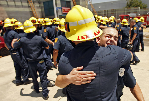 Daniel Balzano, right, gets a hug from Matthew LeBlanc as recruits celebrate following a graduation ceremony on June 12