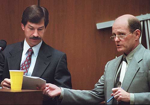 FBI Special Agent Roger Martz, left, reviews a document with defense lawyer Robert Blasier.
