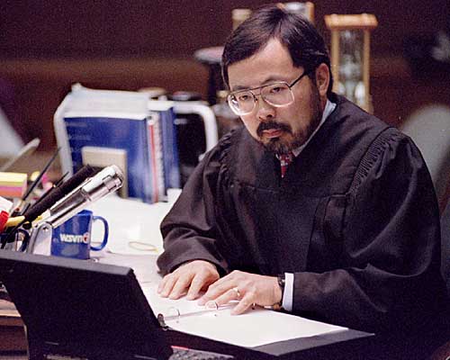 Judge Lance Ito reads from a notebook as he instructs the jury regarding the law and how they are to deliberate. 