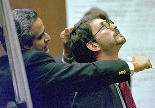 Dr. Lakshmanan Sathyavagiswaran, Los Angeles County coroner, grips the hair of prosecutor Brian Kelberg and uses a ruler to demonstrate how Nicole Brown Simpson's throat may have been slashed. 