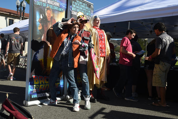"Back To The Future" fans, from left, Shannon Burckhard, Kathy Degoutrie and Markus Geiberger pose in front of posters during Fillmore's celebration of the movie franchise on Thursday, Oct. 22, 2015.