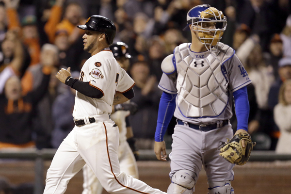 San Francisco Giants pinch runner Gregor Blanco, left, scores the winning run behind Dodgers catcher Yasmani Grandal in the ninth inning of a 3-2 victory.
