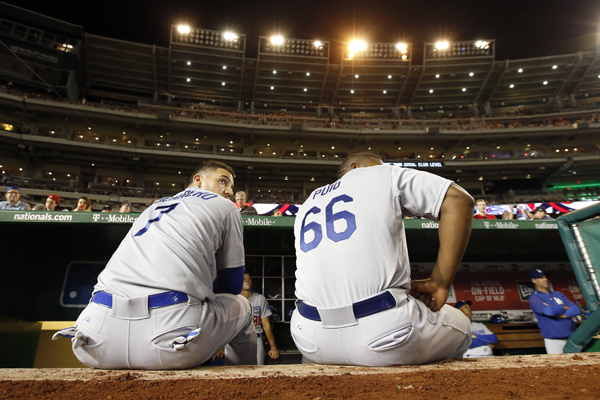 Dodgers teammates Alex Guerrero, left, and Yasiel Puig wait for the stadium lights to be turned back on during a game against the Washington Nationals on July 17, 2015.