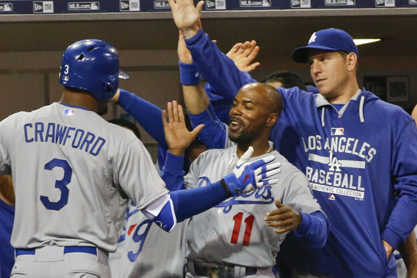 Dodgers left fielder Carl Crawford, left, is congratulated by teammates Jimmy Rollins, center, and A.J. Ellis after hitting a solo home run during the seventh inning of a 3-0 victory over the San Diego Padres.