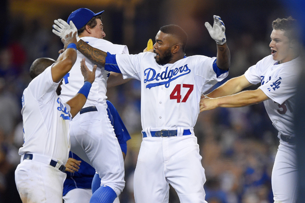 Dodgers second baseman Howie Kendrick, center, celebrates with his teammates after hitting a walk-off single in the ninth inning against the Arizona Diamondbacks.