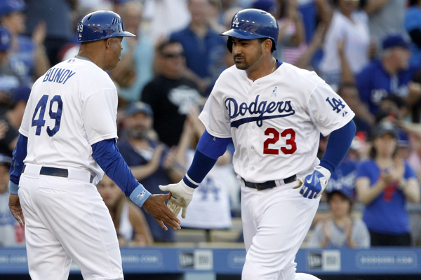 Dodgers third base coach Lorenzo Bundy, left, congratulates first baseman Adrian Gonzalez after his solo home run during the fourth inning of a win over the San Francisco Giants.