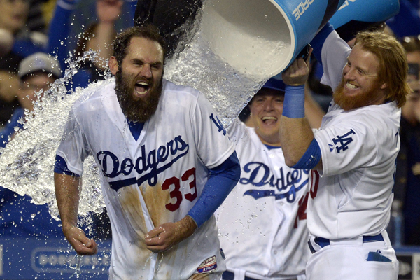 Dodgers left fielder Scott Van Slyke is doused with water by teammate Justin Turner after hitting a walk-off three-run home run against the Miami Marlins.