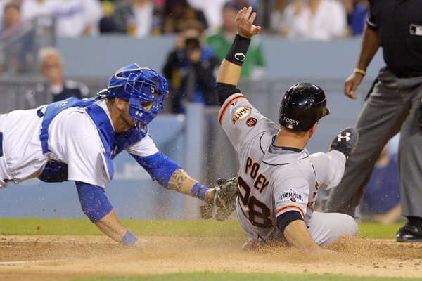 San Francisco Giants catcher Buster Posey, right, beats the tag by Dodgers catcher Yasmani Grandal to score during the seventh inning of the Dodgers' loss.