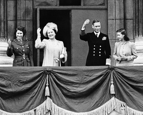 From left to right, Princess Elizabeth, Queen Elizabeth, King George and Princess Margaret stand on a balcony at Buckingham Palace on May 8, 1945, and wave to Londoners celebrating the announcement of Germany's unconditional surrender. 