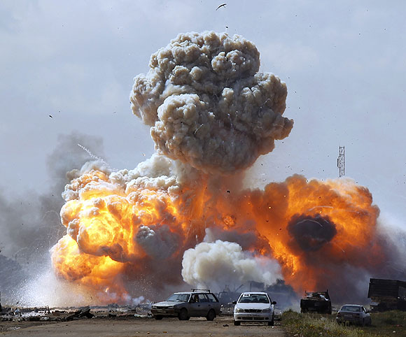 Vehicles belonging to forces loyal to Moammar Kadafi explode after an air strike by coalition forces, along a road between Benghazi and Ajdabiyah.