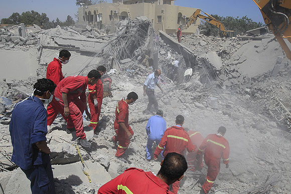 Firefighters search for survivors at a compound belonging to Khweldi Hamedi.