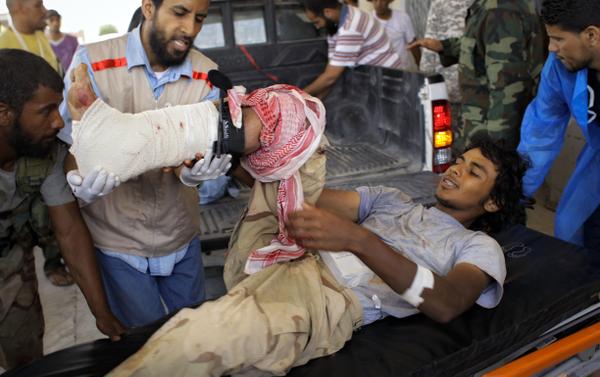 A wounded rebel fighter is transported from a pickup to the hospital in rebel-held Ajdabiya.