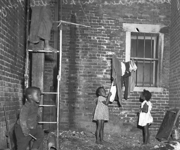 The children of African American war workers play in a Little Tokyo alley. Little Tokyo in Los Angeles was dubbed "Bronzeville" during World War II, as African American families and workers moved into the empty homes and businesses of the relocated Japanese American community.