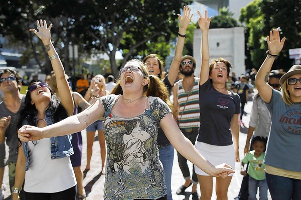 Lauren Rock of Los Angeles dances with dozens of other demonstrators as a band called the Mowglis performs on the steps of City Hall.
