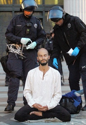 A protester meditates as police move to arrest him at Occupy Oakland. (Nov. 14, 2011)