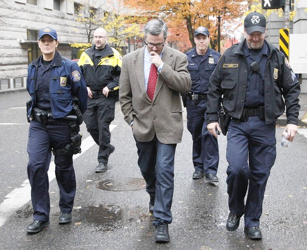 Portland Mayor Sam Adams, flanked by police as he walks to City Hall. (Nov. 14, 2011)