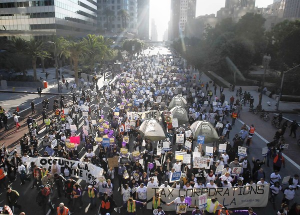 Demonstrators crowd onto a downtown Los Angeles street.