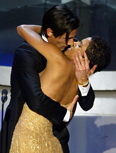 Adrien Brody surprises presenter Halle Berry with a kiss.