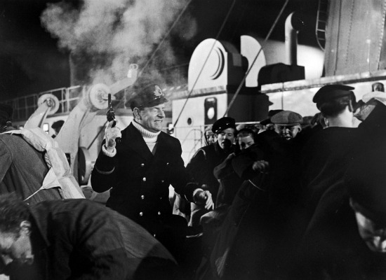 Actor Kenneth More, playing Second Officer Charles Herbert Lightoller, fires his pistol into the air in a scene from the 1958 film.