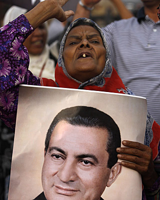 A woman holds a portrait of Hosni Mubarak outside the court