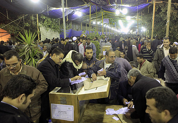 Egyptian election officials count votes in front of a ballot box at a counting center in Giza.