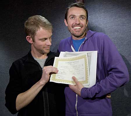 Seth Anderson, left, and Michael Ferguson, right, hold up their marriage certificate and license outside of the Salt Lake County Clerk's Office.