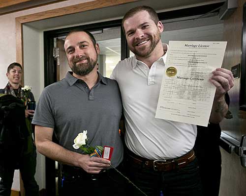 Patrick Donnelly, left, and his partner Ben Bahnsen pose with their marriage license at the Gallatin County Law and Justice Center in Bozeman, Mont. 
