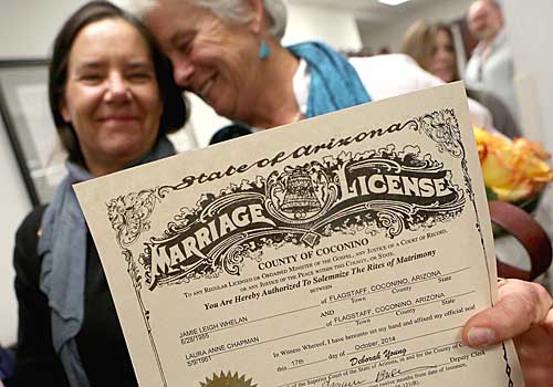 Laura Anne Chapman, left, and Jamie Whelan show their marriage certificate in Flagstaff, Ariz.