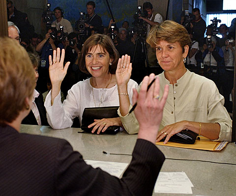 Hillary Goodridge, right, and Julie Goodridge, left, raise their right hands and affirm that everything on their marriage license is correct while at Boston City Hall.

 