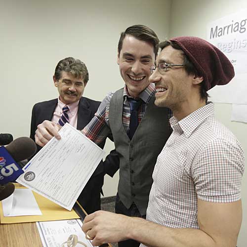 Charlie Gurion, center, and David Wilk hold up their marriage license as Cook County Clerk David Orr, left, looks on.