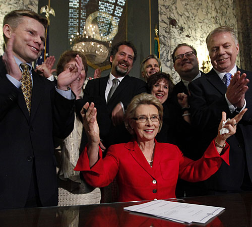 Gov. Chris Gregoire, seated, with legislators and supporters after signing a bill allowing gay marriage. 