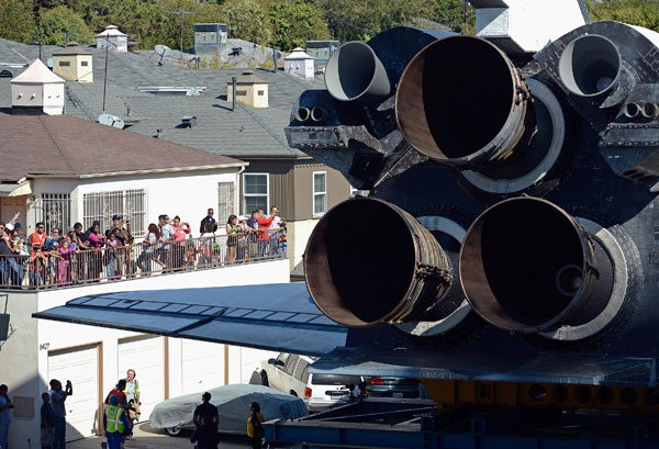 The space shuttle Endeavour squeezes through a neighborhood lined with apartment buildings as it is transported to the California Science Center on Saturday.