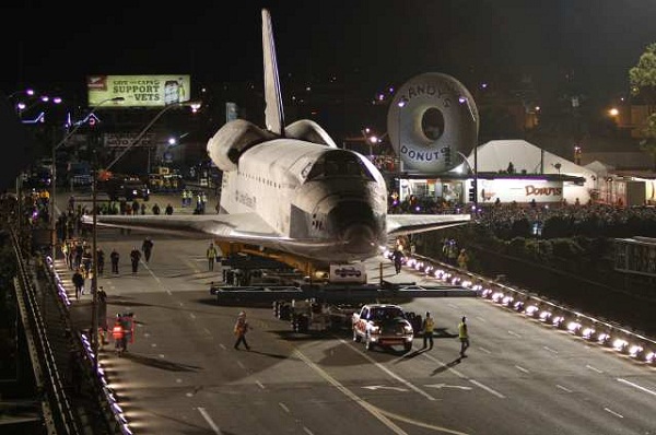Space shuttle Endeavour is pulled along W. Manchester Ave and across the 405 freeway overcrossing by a Toyota pickup truck.