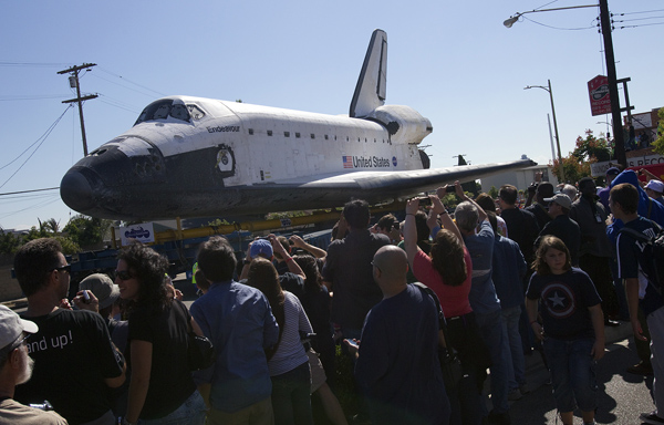 Endeavour towers over pedestrians as it passes by on La Tijera Blvd. in Los Angeles on Friday.