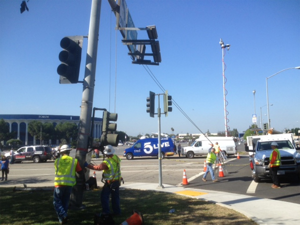 Workers erect a light post at Manchester Boulevard and Kareem Court.