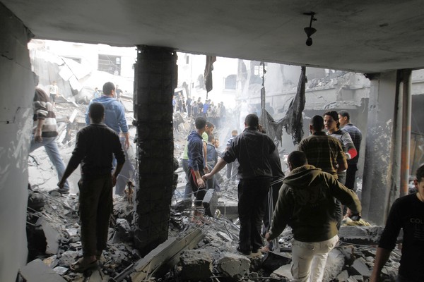Palestinians stand in the rubble of the Dalu family home after an Israeli airstrike in Gaza City. 