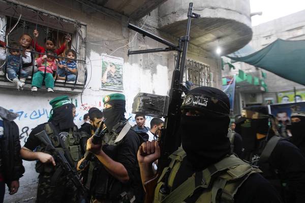 Children watch from a window grate as Hamas militants attend a news conference in Gaza City.