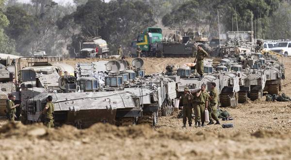 Israeli troops gather near the border with the Gaza Strip. The country is gearing up for a possible ground invasion of the Palestinian territory.