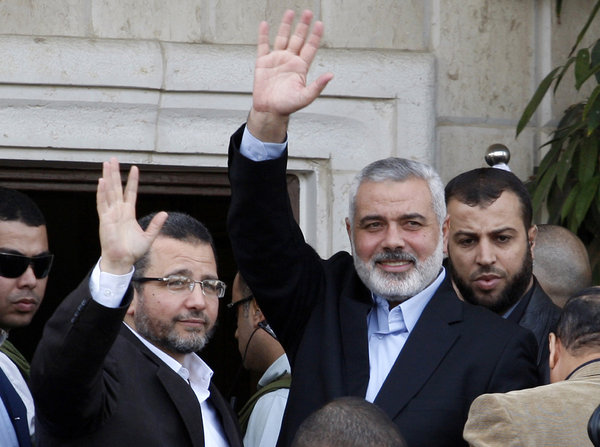 Hamas Prime Minister Ismail Haniyeh, second from the right, and Egyptian Prime Minister Hesham Kandil, left, wave to the crowd as they meet in Gaza City.