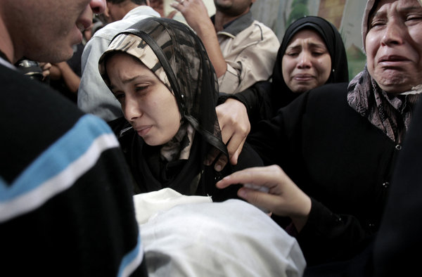 The parents of 11-month-old Omar Masharawi, killed in an Israeli airstrike, hold his body during his funeral in Gaza City on Thursday.
